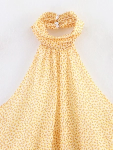 Dettaglio dello scollo all'americana con bottone bianco su abito estivo in chiffon floreale
