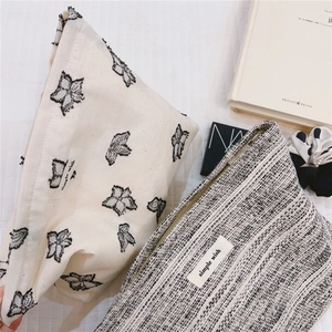Detail of minimalist canvas and tweed makeup bags with simple wish embroidery