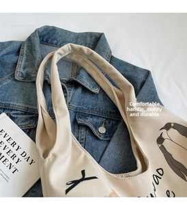 Detail of canvas tote bag featuring cute penguin print and wide comfortable shoulder straps