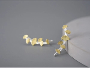Macro detail of S925 sterling silver ginkgo leaf earrings with gold and silver finish