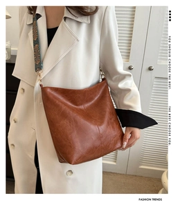 Detail of vintage brown PU leather tote with ethnic geometric patterned wide shoulder strap