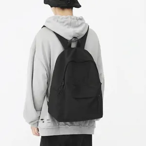 Rear view of a stylish black nylon backpack worn by a model on a light grey background