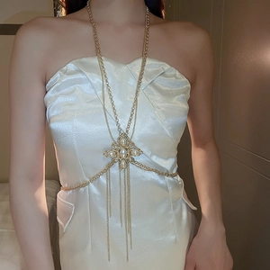 Detail of layered gold body chain featuring pearls, rhinestones, and cross fringe pendant