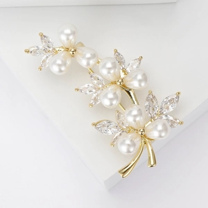 Macro detail of luxury pearl vine brooch with zircon inlays on golden metal base