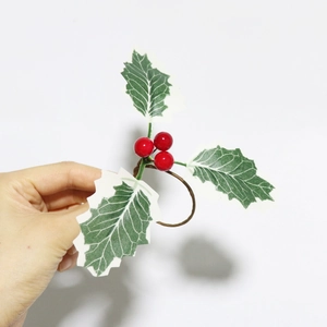 Detail eines Weihnachts-Serviettenrings mit roten Beeren und grünen Stechpalmenblättern