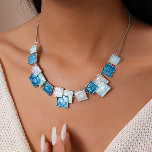 Detail of blue and white enamel geometric square pendant necklace on female model