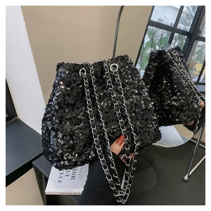 Macro shot of shimmering black sequins and silver chain strap on a designer bucket bag