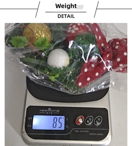 Detailed view of mini pine needle Christmas tree ornaments weighing 85g on a scale