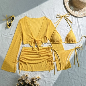 Dettaglio del bikini giallo con trama a nido d'ape e gonna da spiaggia in pieno sole