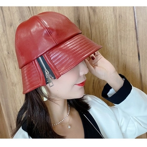 Detail of red leather bucket hat featuring metallic zipper and precision stitching line