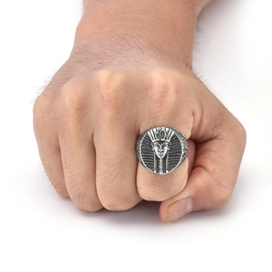 Detailed view of a vintage silver Egyptian Pharaoh ring worn on a man's finger