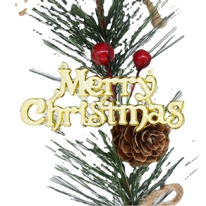 Branche de Noël avec aiguilles de pin, cônes, baies rouges et signe Merry Christmas doré