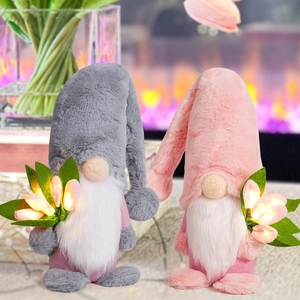 Close-up of pink and grey LED glowing gnome plush dolls with tulip accents in cozy home setting