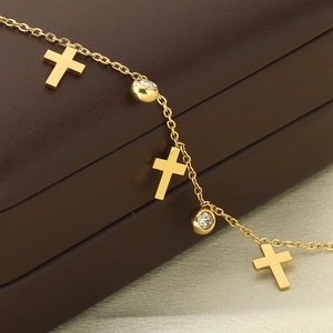 Détail macro de la chevillère en or 18k avec pendentifs croix et zircons sur cuir
