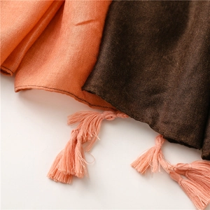 Detail of two-tone gradient scarf showing soft texture and woven fringe tassels