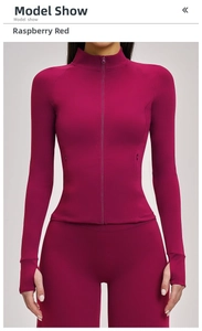 Gros plan d'une veste de yoga rouge framboise avec poignets passe-pouce et fermeture