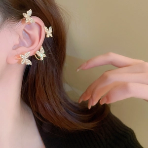 Detail view of four butterfly ear cuffs with sparkling crystals on gold metal base