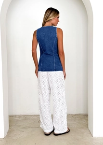 Back view of a sleeveless denim top and white lace wide-leg pants on a model