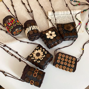 Detail of handmade ethnic crossbody bag with coconut shell, wood beads and flower patterns