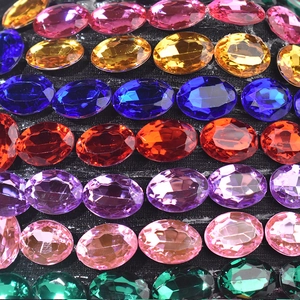 Dettaglio macro di strass ovali multicolore incastonati a mano su un cappello nero
