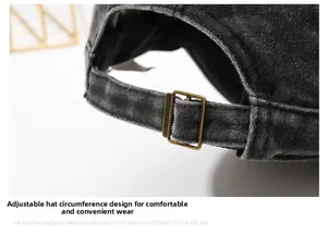 Detail of adjustable vintage bronze buckle on black washed denim cap for custom fit