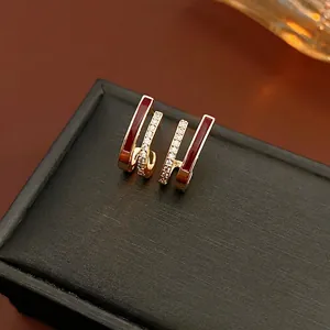 Elegant U-shape gold earrings with red enamel and pavé white zircon details