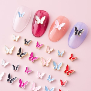 Detailed view of 3D butterfly nail charms in various colors on manicure tips