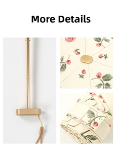 Detail view of cherry print folding umbrella with gold telescopic handle and matching strap