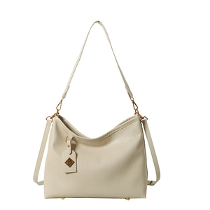 Chic beige PU leather tote bag for women with gold charm and adjustable shoulder strap