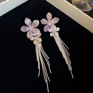 Detail of pink floral resin earrings with shimmering petals and silver tassels