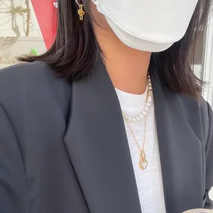 Elegant layered set with heart lock necklace, pearl strand, and gold knot earrings