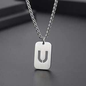 Détail macro du collier avec pendentif lettre U évidée en acier inoxydable argenté
