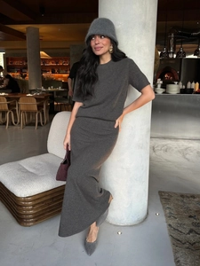 Dark grey knitted two-piece set with short sleeve top and long skirt in modern cafe setting