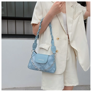 Light blue quilted bag with woven strap and decorative metal floral chain detail