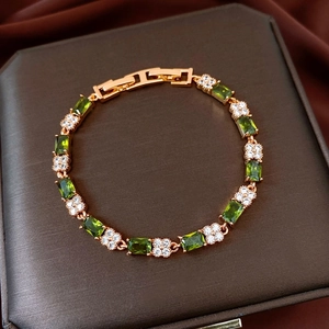 Detail view of 18k gold-plated bracelet with green zircon stones and white flower gems