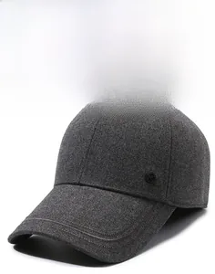 Detail of dark grey wool blend baseball cap with sturdy brim and small metal logo side accent