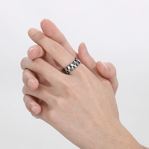 Close-up of men's wide titanium steel ring with textured water wave pattern and grooves