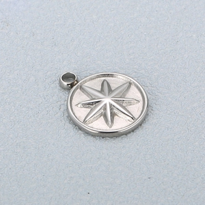 Vue macro d'un pendentif rond en acier inoxydable argenté avec motif d'étoile