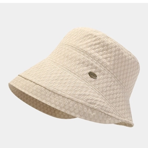 Beige seersucker bucket hat with bubble texture and metal logo detail for sun protection