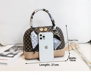 Shell shaped handbag with geometric pattern and scarf wrapped handle, size 21x17x10cm