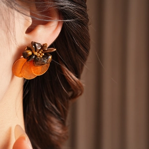 Vintage shell tiger eye style earrings with warm brown resin clusters on model