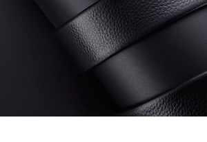 Macro shot of men's black leather belt showing premium lychee texture and fine stitching