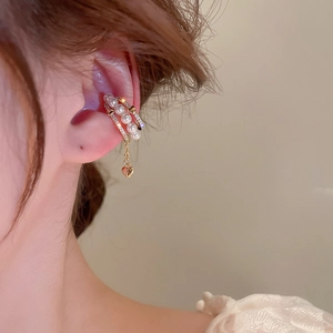 Detail of gold-plated three-layer heart ear cuff with pearls and cubic zirconia on model
