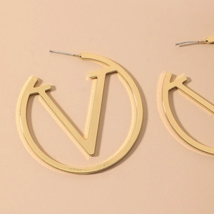 Chic gold oversized round hoop earrings with hollow V-logo design in polished metal finish