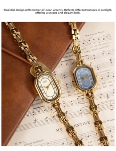 Close-up of vintage oval quartz watch with gold chain bracelet and mother of pearl dial