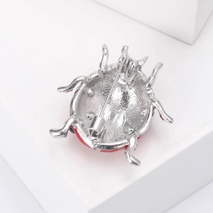 Detailed macro view of the silver ladybug brooch back showing its sturdy pin structure