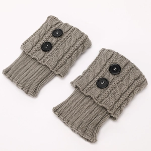 Detailed close-up of grey cable knit leg warmers with fold-over cuffs and black buttons