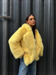 Fashionable vibrant yellow faux fur jacket with fluffy lapels and long sleeves for winter