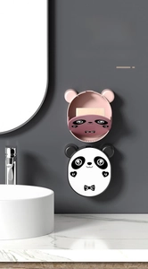 Detail of panda soap holders in pink and black on a bathroom wall with drainage