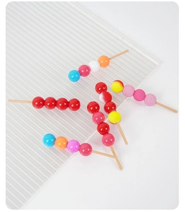 Vue macro de mini figurines de fruits confits en résine colorée au fini brillant